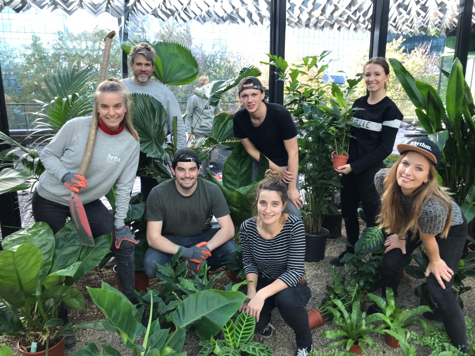 Members of the Hrbs team getting their hands in the soil to build indoor gardens at the new Nationale Postcode Loterij in Amsterdam.
