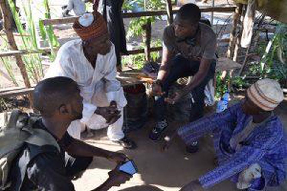 Two Hello Tractor booking agents speak with farmers about available services.(PHOTO: HELLO TRACTOR)
