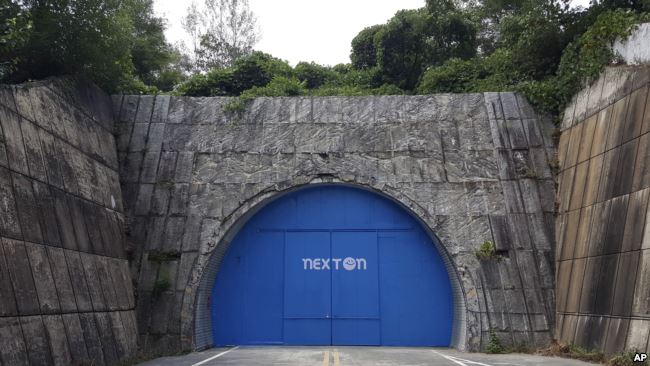 In this Aug. 9, 2018 photo, a set of bright blue doors covers the entrance of the tunnel that holds the farm NextOn in Okcheon, South Korea.(AP Photo/Han Myung Oh)